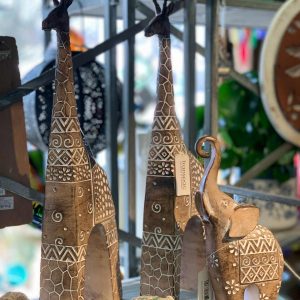 wooden statues of giraffes and elephants