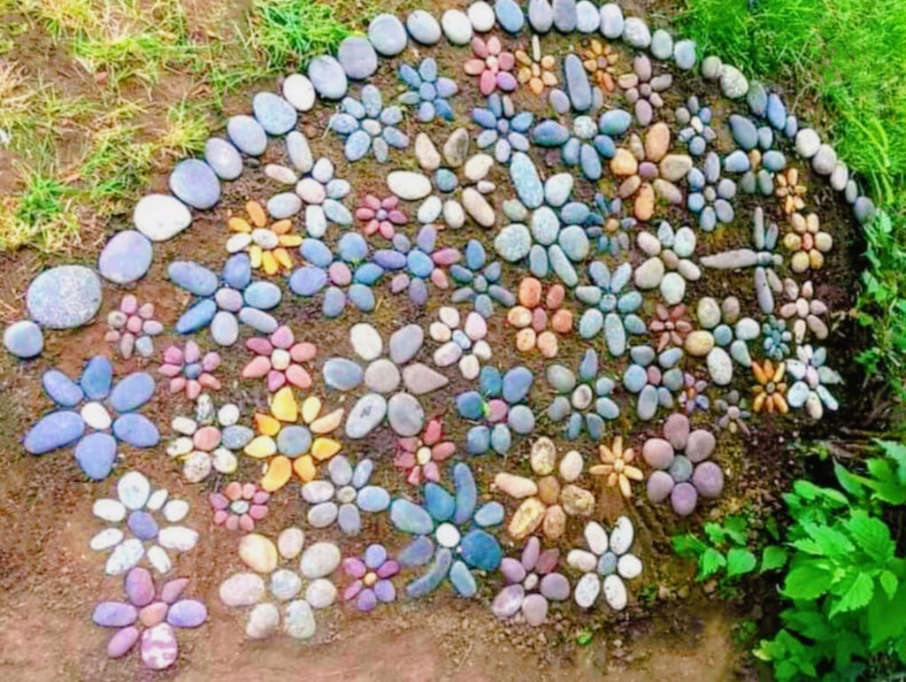 Arrangement of colored stones, small and large stones painted in various colors to look beautiful and then placed in the shape of flowers to be used to decorate the place and for beaut